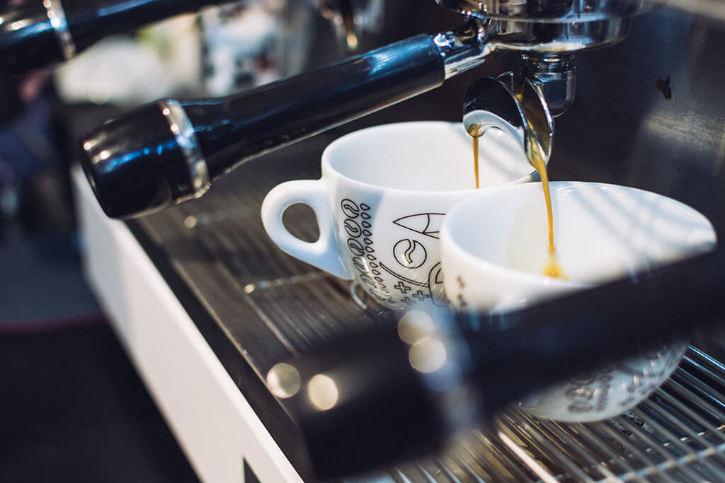 Coffee machine pouring espresso on two cups
